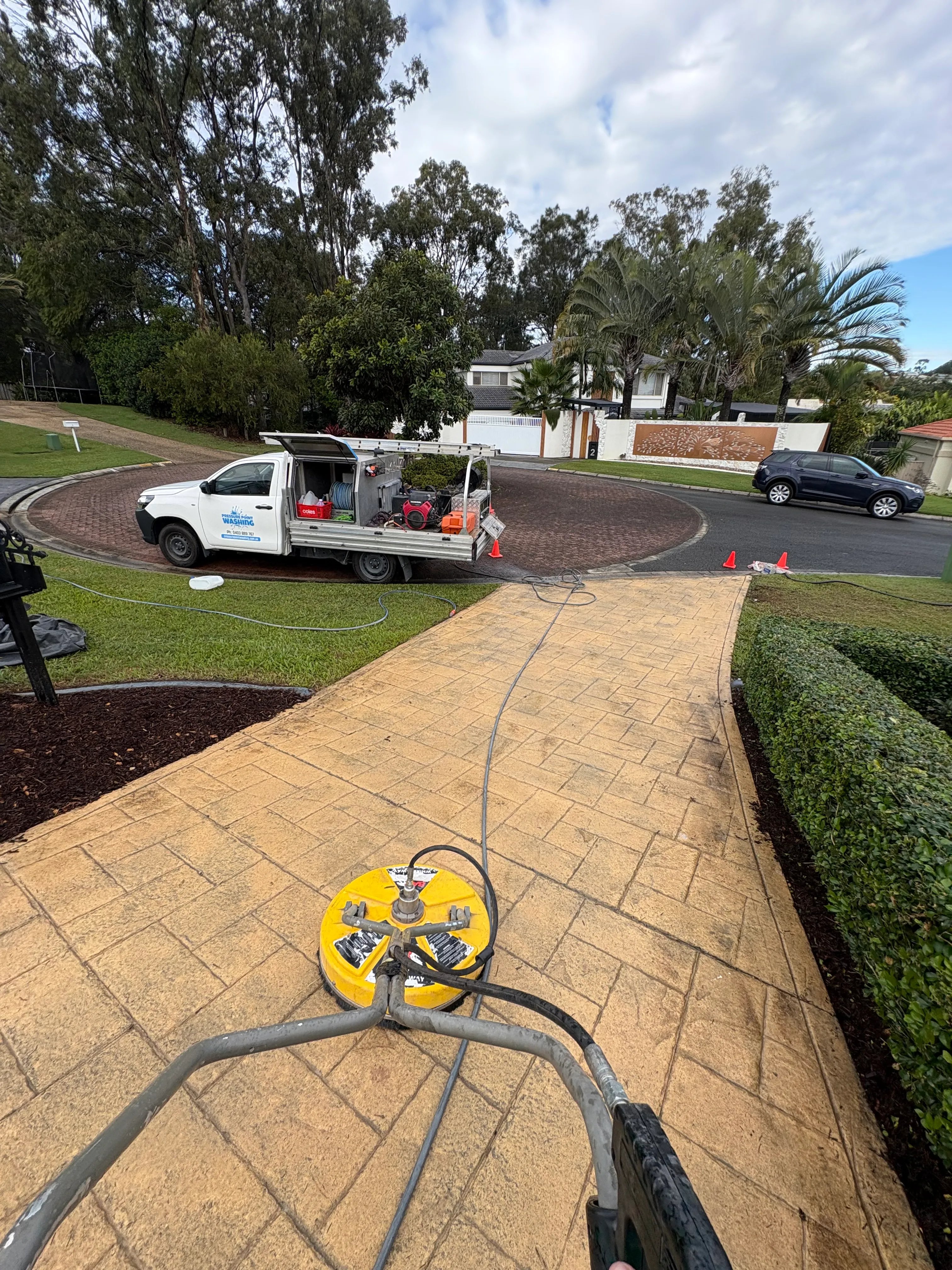 Professional driveway pressure cleaning with a surface cleaner and work vehicle